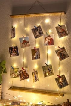 a string of lights hanging from the side of a wall with pictures attached to it