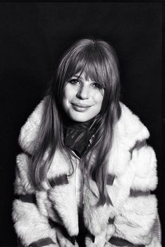 a black and white photo of a woman wearing a fur coat