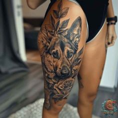 a woman with a tattoo on her thigh shows off her dog's face and flowers