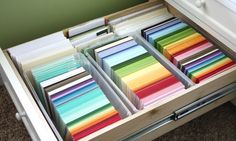 the drawers are filled with different colored papers