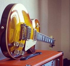 an electric guitar sitting on top of a speaker