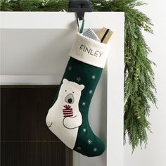 a christmas stocking hanging from the wall with a bear on it's side