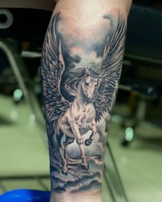 a person with a tattoo on their arm and leg that has an angel riding a horse