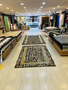 a store filled with lots of different types of rugs and bedspreads on the floor