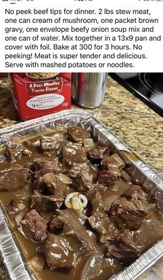 a pan filled with meat and gravy on top of a counter