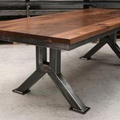 a wooden table sitting on top of a white floor next to a train track in the background