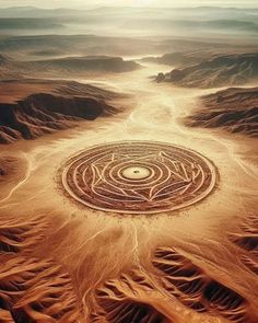 an aerial view of a desert with a circular design in the middle