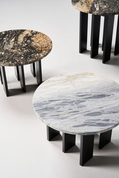 three tables with marble tops and black legs