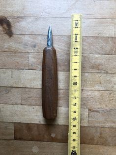 a piece of wood sitting next to a measuring tape on top of a wooden floor