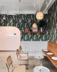 the interior of a restaurant with chairs and tables in front of a wallpapered wall