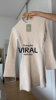 a person holding up a white sweater with the words trying the viral on it