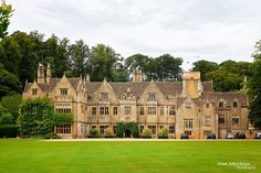 a large building with lots of windows in the middle of a lush green park area