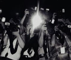 a group of people holding up cameras in the air