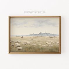 a painting hanging on the wall above a white wall with a brown frame that has sheep in it