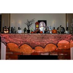 a mantle with candles and decorations on it in front of a fireplace decorated for halloween