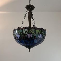 a stained glass light hanging from a ceiling fixture