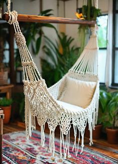 a white hammock hanging from a wooden pole in a room with potted plants