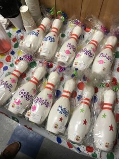 many bowling pins are wrapped in plastic and sitting on the table next to each other