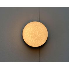 a light that is on the side of a wall in a room with grey walls