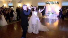 the bride and groom are dancing together at their wedding reception in front of an audience