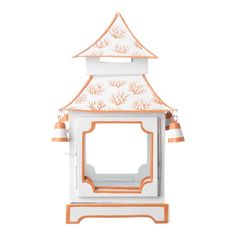 an orange and white birdhouse with two bells on it's roof, in front of a white background