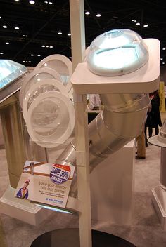 a large white machine sitting on top of a display case in a room filled with people