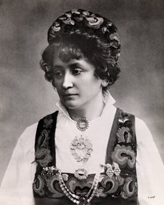 an old black and white photo of a woman in traditional clothing