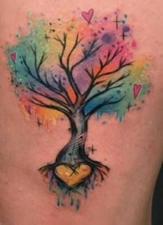 a colorful tree tattoo on the back of a woman's lower back, with hearts in it