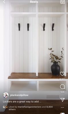 a white shelf with some black vases on it