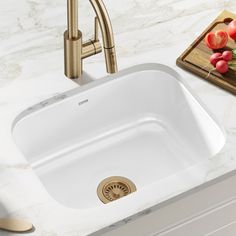 a white sink sitting on top of a counter next to a cutting board and knife