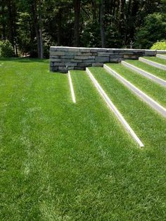 steps leading up to a stone wall in the grass