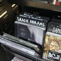 several cds are stacked on top of each other in a store display case with black and white labels