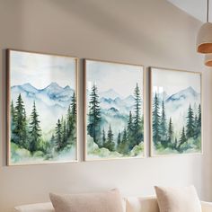 three paintings hanging on the wall above a couch in front of a window with white pillows