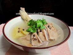 a white bowl filled with soup and garnished with parsley