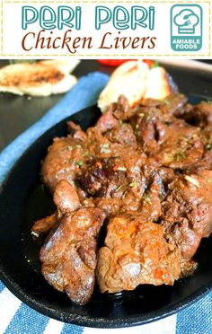 a black plate topped with meat covered in sauce