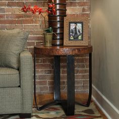 a living room with a couch, chair and table in front of a brick wall