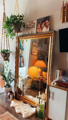 a mirror sitting on top of a wooden table next to a lamp and potted plant