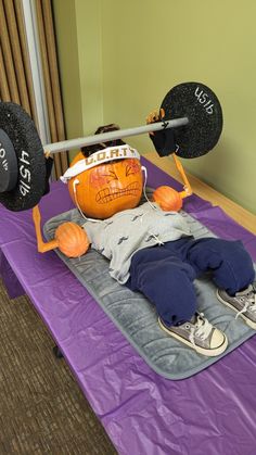 a man laying on top of a purple mat next to a barbell