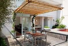 an outdoor patio with table and chairs under a pergolated awning over it