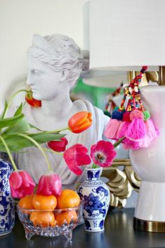 a table with vases, flowers and other decorative items on it's surface