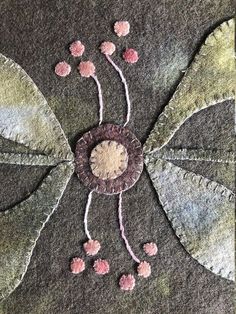 a close up of a piece of cloth with flowers and leaves on the back of it