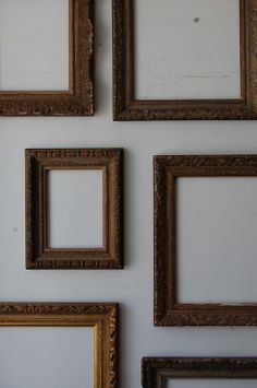 four gold frames are hanging on the wall