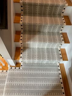 a carpeted staircase with wooden handrails leading up