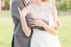 a bride and groom embracing each other in the grass