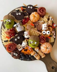 a platter filled with halloween treats and candies on top of a wooden spatula