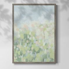 an abstract painting hangs on the wall next to a vase with flowers and leaves in it