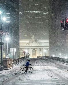 a bicyclist rides through the snow in new york city's financial district