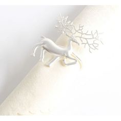 a napkin holder with a white horse on it's side and branches in the middle