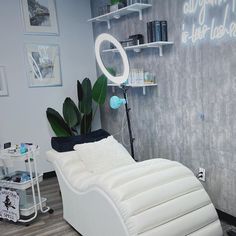 a white chair sitting in front of a mirror on top of a wooden floor next to a wall