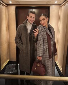 a man and woman taking a selfie in an elevator